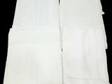 trois serviettes blanches sont pliées les unes sur les autres sur une surface noire