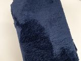 une serviette bleu marine pliée sur une surface blanche