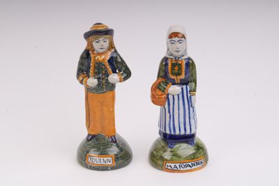 deux figurines de personnes se tenant l'une à côté de l'autre sur une surface blanche