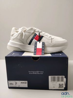 une boîte sur laquelle est posée une paire de baskets blanches