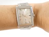 a silver watch on the wrist of a woman