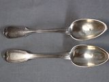 two spoons sitting next to each other on a table