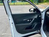 a white car with its door open in a parking lot