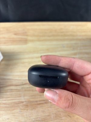 une personne tenant un petit objet noir dans la main