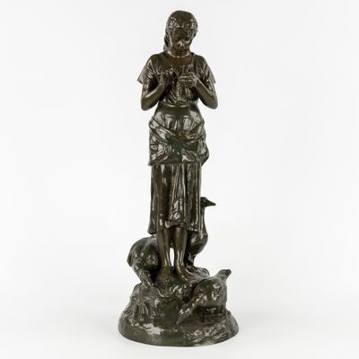 une statue en bronze représentant une femme tenant un oiseau sur un rocher