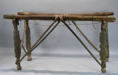 une petite table en bois sur laquelle se trouve un tas de bâtons