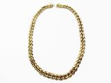 gros plan d'un collier en chaîne en or sur fond blanc