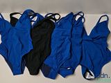 trois maillots de bain bleus et noirs alignés sur une surface blanche