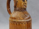 a brown vase with a face on it