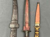 three different types of knives are displayed on a gray surface