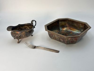 une paire de plats en métal argenté avec une cuillère et un repose-cuillère posés sur une table