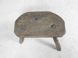 a small wooden stool with holes in it