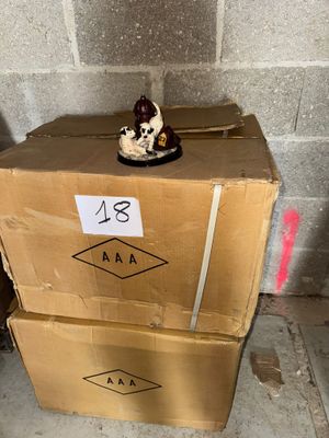 une petite figurine posée sur une boîte en carton