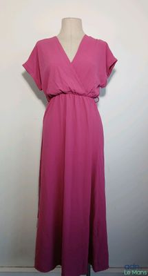 une robe rose posée sur un mannequin, devant un mur blanc