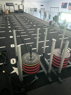 une photo d'une salle de sport avec un support à haltères