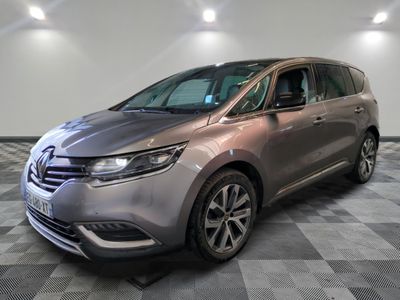 La camionnette argentée est garée sur un sol en carrelage à damier.