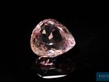 a close up of a pink diamond on a black surface