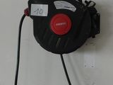un tuyau noir et rouge fixé à un mur blanc