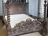 un lit en bois avec une tête et un pied de lit sculptés