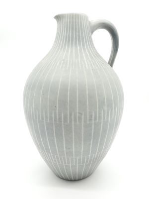 un vase blanc posé sur une surface blanche