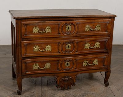 an antique chest of drawers with brass handles on a wooden floor
