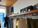 many clothes hanging on a rack in a store