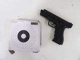 un pistolet et une cible posés sur une table blanche