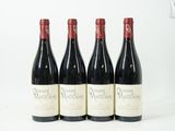 quatre bouteilles de vin sont alignées sur une surface blanche