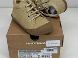 des chaussures de petit garçon dans une boîte posée sur une surface blanche
