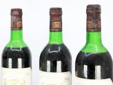 three bottles of wine are lined up in a row on a table