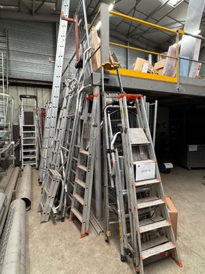 many ladders that are stacked up in a warehouse