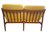 pair of mid century danish teak lounge chairs with yellow cushions