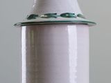 a white and green jar sitting on top of a table
