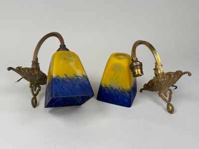 deux lampes en verre bleu et jaune posées sur une surface blanche