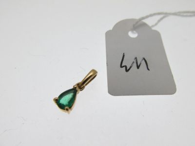 un petit pendentif vert en forme de larme auquel est attachée une étiquette