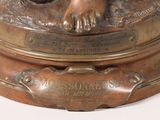 a bronze statue of a dog laying on top of a box