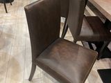 tables and chairs in a restaurant with wooden walls and tile flooring