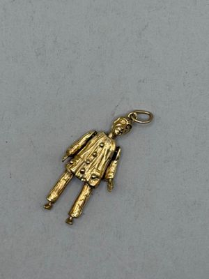 a close up of a gold charm on a white surface