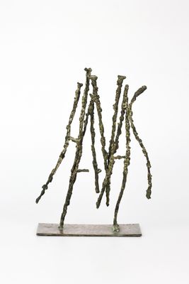 une image représentant une sculpture composée de bâtons posée sur une surface blanche