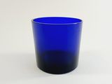 a blue glass cup sitting on a white surface