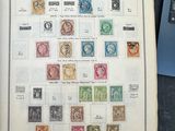 un livre ouvert, orné de timbres, à côté d'un ordinateur portable