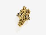 un gros plan d'une bague en or ornée d'une statuette