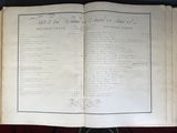 an old open book with writing on it sitting on top of a table