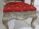 a silver chair with red upholstered seat on a white background