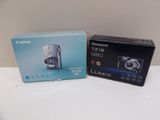 two boxed cameras sitting on a table next to each other