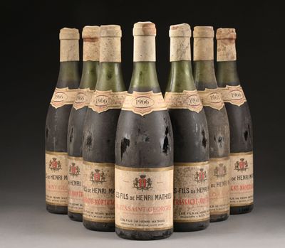 six bouteilles de vin sont alignées sur une table