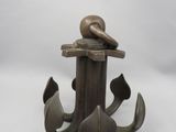 une statue en bronze représentant un oiseau posé sur une ancre