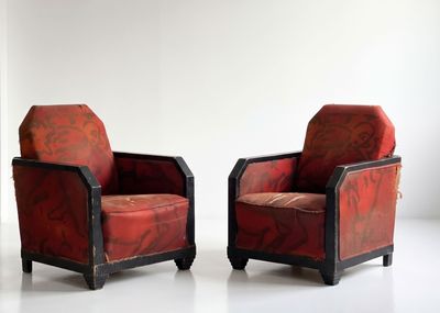 pair of red upholstered chairs in a white room