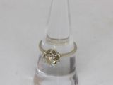 a ring with a diamond on it sitting on a clear glass