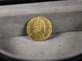 un gros plan sur une pièce d'or dans une boîte posée sur une table